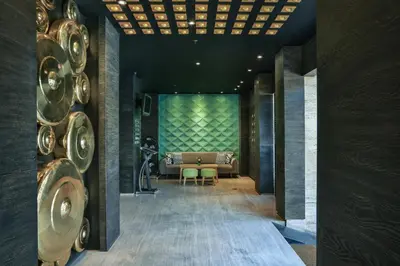 a room with a couch and a table and chairs at Ohana Hotel Kuta in Kuta