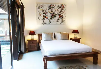 a bedroom with a bed and a painting on the wall at Villa Marick in Seminyak