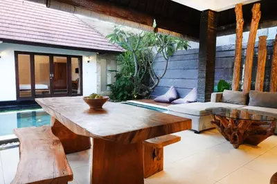 a living room with a wooden table and a couch at Villa Marick in Seminyak