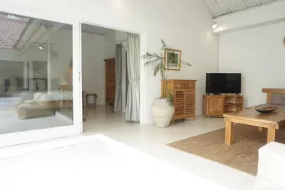 a living room with a tv and a table at Villa Pagu in Seminyak