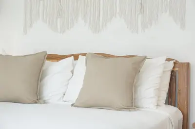 a white bed with white pillows on it at Villa Pagu in Seminyak