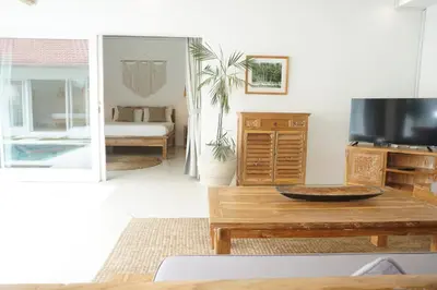 a living room with a table and a tv at Villa Pagu in Seminyak