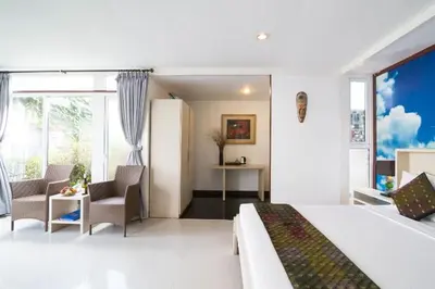 a bedroom with a bed and a table and chairs at Aqua Bali Villa in Canggu
