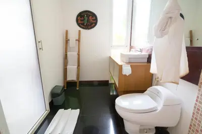 a bathroom with a white toilet and a window at Aqua Bali Villa in Canggu
