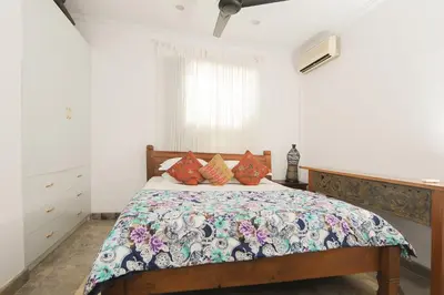 a bedroom with a bed with a floral bedspread at Bali Court Hotel & Apartment in Legian