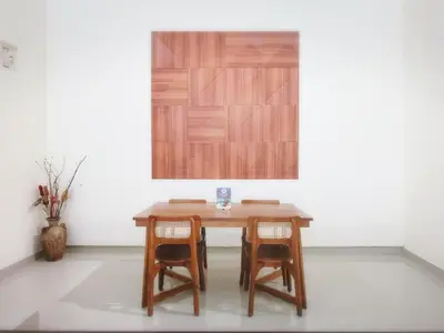 a wooden table with two chairs in a room at Kumpul Kumpul Villa Seminyak - CHSE Certified in Seminyak