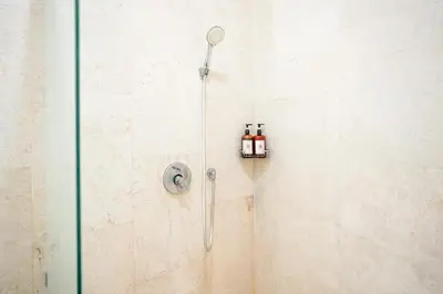 a shower with two bottles of essential oils on the wall at Villa Harmony - Residence in Seminyak