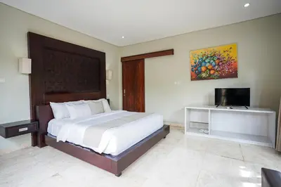 a bedroom with a large bed and a television at Villa Harmony - Residence in Seminyak