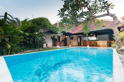a swimming pool in front of a villa at Bali Royal Heritage Villas in Seminyak