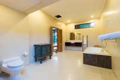 a bathroom with a toilet and a sink and a tub at Bali Royal Heritage Villas in Seminyak