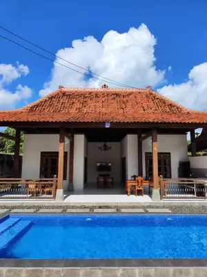 a villa with a swimming pool and a pavilion at Bali Royal Heritage Villas in Seminyak