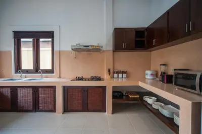 a kitchen with a sink and a microwave at Casa Priya Seminyak in Kerobokan