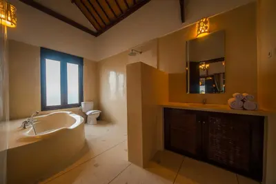 a bathroom with a tub and a sink and a mirror at Casa Priya Seminyak in Kerobokan