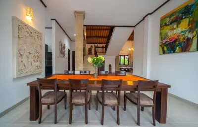 a dining room with a wooden table and chairs at Casa Priya Seminyak in Kerobokan