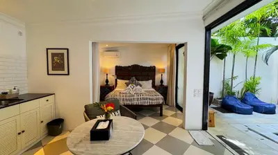 a bedroom with a bed and a table in a room at Villa Bugis Kayu Aya Seminyak in Seminyak