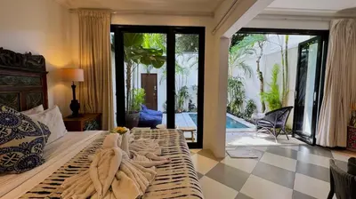 a bedroom with a bed with towels on it at Villa Bugis Kayu Aya Seminyak in Seminyak