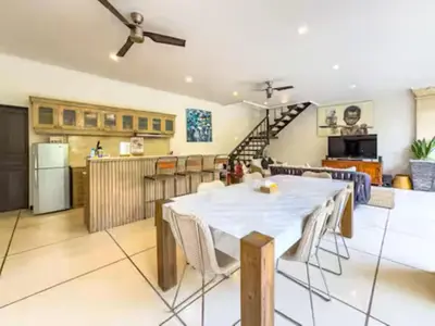 a kitchen and a living room with a table and chairs at Villa Bugis Kayu Aya Seminyak in Seminyak