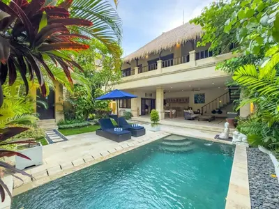 a villa with a swimming pool in front of a house at Villa Bugis Kayu Aya Seminyak in Seminyak