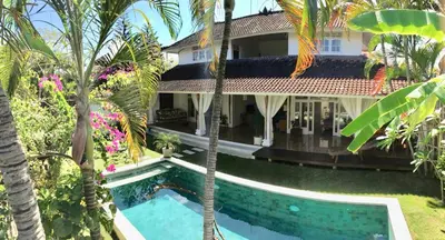 an aerial view of a house with a swimming pool and palm trees at Villa Jalun in Seminyak