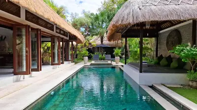 a swimming pool in front of a villa at Villa Bugis Drupadi Seminyak in Seminyak