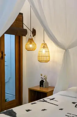 a bedroom with two pendant lights and a bed at Unicorn Shelter Villa in Seminyak