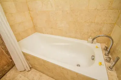 a bath tub with a faucet in a bathroom at Abian Biu Mansion in Canggu