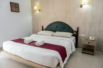 a bedroom with a large bed with two towels on it at Abian Biu Mansion in Canggu