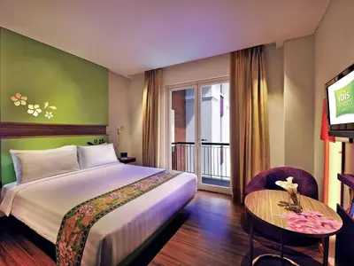 a hotel room with a bed and a table at Ibis Styles Bali Denpasar in Denpasar