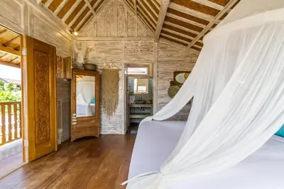 a bed in a room with a wooden ceiling at Villa Opaline by Alfred in Bali in Seminyak