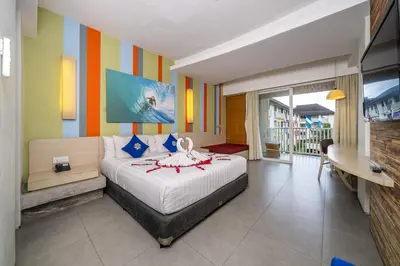 a bedroom with a bed in a room with colorful walls at Bliss Surfer Hotel Legian in Legian