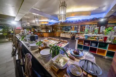 a restaurant with a long table with plates of food at Bliss Surfer Hotel Legian in Legian