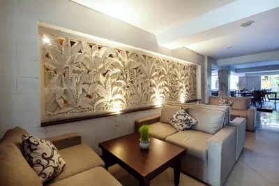 a living room with two couches and a wall mural at Royal Regantris Kuta in Kuta
