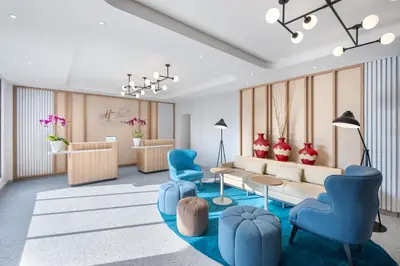 a living room with blue chairs and a couch at Holiday Inn Express Bali Sunset Road by IHG in Kuta