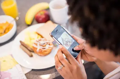 a woman taking a picture of a plate of food at Holiday Inn Express Bali Sunset Road by IHG in Kuta