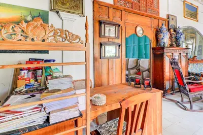 a room with a wooden desk and a shelf with books at Collection O Sanur Near Bali Exotic Marine Park in Sanur