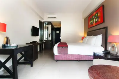 a hotel room with a bed and a desk at 100 Sunset Kuta Hotel & Ballroom in Kuta
