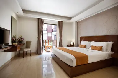 a hotel room with a bed and a television at d'primahotel Seminyak in Seminyak