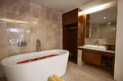 a bathroom with a large white tub and a sink at d'primahotel Seminyak in Seminyak