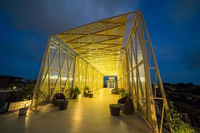 a lit up building with potted plants on a balcony at Ananta Legian Hotel in Legian