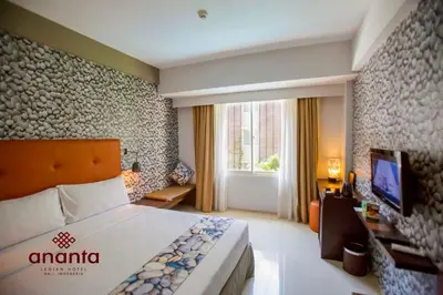 a hotel room with a bed and a television at Ananta Legian Hotel in Legian