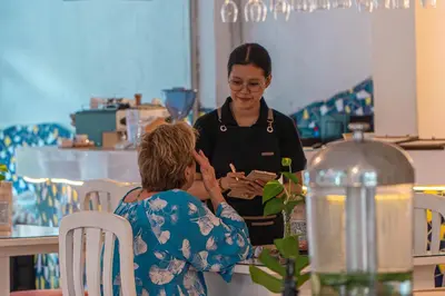 a woman standing next to a woman in a kitchen at Bali Summer Hotel by Amerta in Kuta