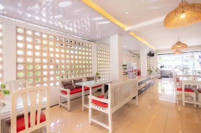 a restaurant with tables and chairs and a wall of plates at Bali Summer Hotel by Amerta in Kuta