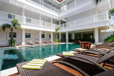 a swimming pool with lounge chairs and a swimming pool at Samsara Inn in Legian