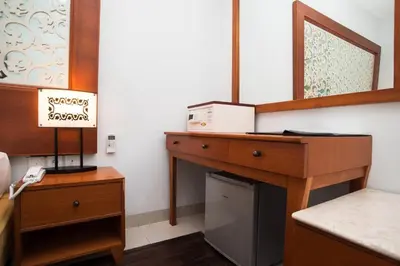 a room with a wooden dresser with a refrigerator at Samsara Inn in Legian