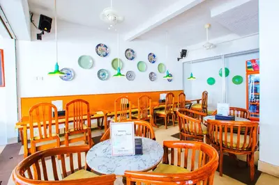 a dining room with tables and chairs and plates on the wall at Samsara Inn in Legian