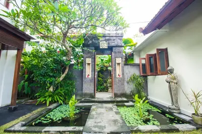 a pathway leading to a house with a tree at Amore Villas in Canggu