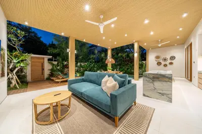 a living room with a blue couch and a table at Villa Esa Seminyak in Seminyak