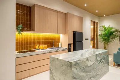 a kitchen with a marble counter top and yellow tiles at Villa Esa Seminyak in Seminyak