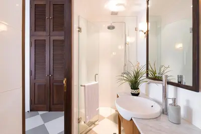 a white bathroom with a sink and a mirror at Villa Luma in Seminyak