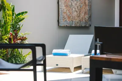a room with two chairs and a table and a rug at Villa Luma in Seminyak